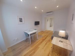a white living room with a table and a chair at Flor do Padrão in Elvas