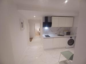 a kitchen with white cabinets and a washing machine at Flor do Padrão in Elvas +20 photos