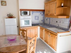 a kitchen with a table and a white refrigerator at Appartement paisible à Saint-Crepin avec vue sur la montagne in Saint-Crépin