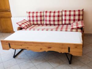a couch with red and white pillows on it at Appartement paisible à Saint-Crepin avec vue sur la montagne in Saint-Crépin