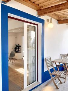 a room with blue walls and a table and chairs at Comfortable Studio in Santiago do Cacém, private pool, 65 m² in Santiago do Cacém