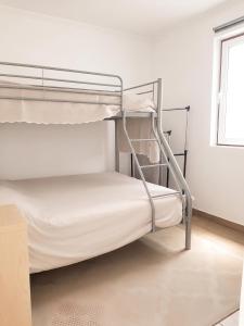 two bunk beds in a room with a window at Comfortable Studio in Santiago do Cacém, private pool, 65 m² in Santiago do Cacém +21 photos
