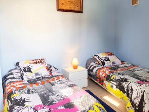 two beds sitting next to each other in a bedroom at Maison confortable à Ver-sur-Mer avec jardin privé in Ver-sur-Mer +16 photos