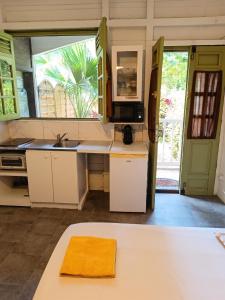 a kitchen with white cabinets and a sink at Studio confortable à Schoelcher - 16 m² - Jardin privé in Schœlcher
