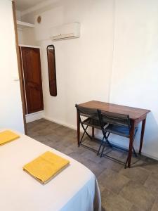 a room with a desk and a table and a chair at Studio confortable à Schoelcher - 16 m² - Jardin privé in Schœlcher