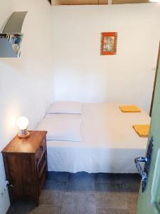 a bedroom with a white bed and a wooden table at Studio confortable à Schoelcher - 16 m² - Jardin privé in Schœlcher +16 photos