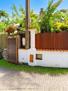 a house with a woodburning stove in front of a fence at Studio confortable à Schoelcher - 16 m² - Jardin privé in Schœlcher