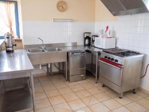 a kitchen with a stove and a sink at Grande maison conviviale à Saint-Côme-d'Olt avec jardin et cheminée in Saint-Côme-dʼOlt