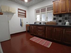 a kitchen with wooden cabinets and a refrigerator at Avona Villa in Bopitiya
