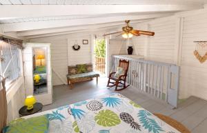 a porch with a bed and a ceiling fan at Appartement cosy au Carbet avec balcon et vue sur mer - 70 m² in Le Carbet