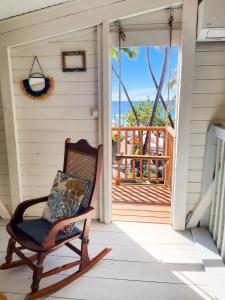 a rocking chair on the porch of a house at Appartement cosy au Carbet avec balcon et vue sur mer - 70 m² in Le Carbet