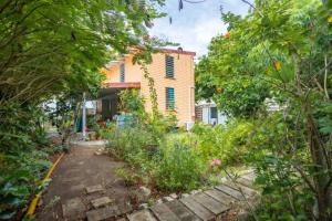 a garden in front of a house with trees at Appartement cosy au Carbet avec balcon et vue sur mer - 70 m² in Le Carbet