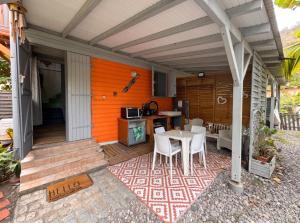 a patio with a table and chairs on a house at Appartement cosy au Carbet avec balcon et vue sur mer - 70 m² in Le Carbet