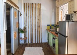 a small kitchen with a refrigerator and a sink at Appartement cosy au Carbet avec balcon et vue sur mer - 70 m² in Le Carbet +29 photos