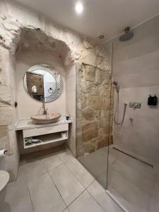 a bathroom with a shower and a sink and a mirror at Konak Zenobia in Midyat