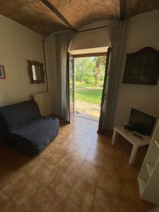 a bedroom with a bed and a television and a door at Atelier Suvereto in Suvereto