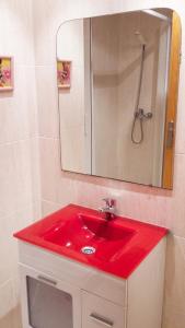 a red sink in a bathroom with a mirror at Apartment with pool in Águilas 75 m² with sea view in Águilas