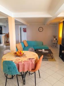 a living room with a table and a blue couch at Appartement confortable à Sainte-Luce avec jacuzzi in Sainte-Luce