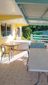 a patio with two tables and chairs and a couch at Appartement confortable à Sainte-Luce avec jacuzzi in Sainte-Luce