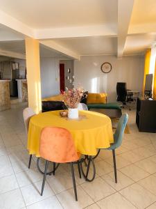 a yellow table and chairs in a living room at Appartement confortable à Sainte-Luce avec jacuzzi in Sainte-Luce