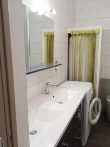 a bathroom with a white sink and a mirror at Appartement charmant avec vue sur lac et montagne – 75 m² in Fontrabiouse