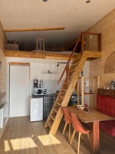 a kitchen with a wooden staircase and a table with chairs at La Palissandre in Tallard