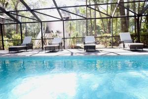 a group of chairs sitting next to a swimming pool at Charming Oasis - Ultimate Rustic Getaway! in St. Augustine
