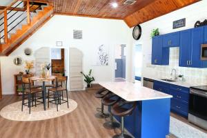 a kitchen with blue cabinets and a table with stools at Charming Oasis - Ultimate Rustic Getaway! in St. Augustine