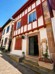 a building with a green door on a street at Plan B - Chambres & Studios in Saint-Jean-Pied-de-Port