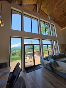 a living room with large windows and couches at CabanaFriendly in Râşnov