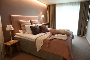 a bedroom with a bed with pillows and a window at Boutique hotel SAVOIR in Savonlinna