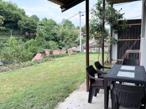 a table and chairs on a patio with a yard at Sweet Home in Tuzla