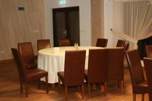 a conference room with a white table and chairs at Casa Roua Munților in Dămuc