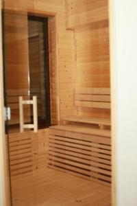 a wooden sauna with a white chair in it at Casa Roua Munților in Dămuc