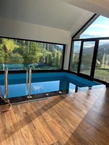 a room with large windows and a glass floor at Casa Roua Munților in Dămuc