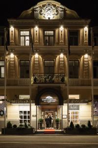 a building with two people standing outside of it at night at Continental du Sud in Ystad