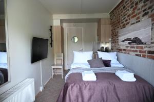 a bedroom with a large bed with a brick wall at Boutique hotel SAVOIR in Savonlinna +20 photos
