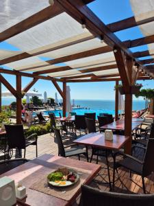 an outdoor patio with tables and chairs and the ocean at Villa Lavanda in Vapnyarka