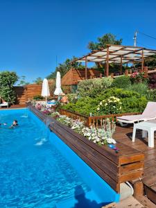 a pool with a wooden deck and a swimming pool with a garden at Villa Lavanda in Vapnyarka