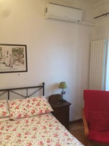 een slaapkamer met een bed en een rode stoel bij B&B la casa di Arturo in Turijn