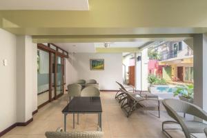 a room with chairs and a table and a pool at Cozytel Chiangmai in Chiang Mai