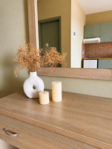 a white vase and two candles on a dresser at Anastasis Apartments in Trapezaki