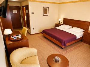 a hotel room with a bed and a chair at Hotel Laguna in Privlaka +49 photos