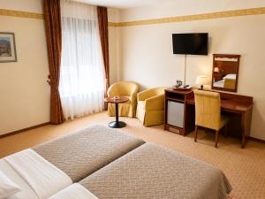 a hotel room with a bed and a desk at Hotel Laguna in Privlaka