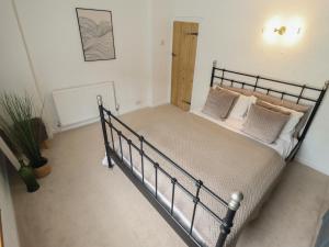 a bedroom with a metal bed in a room at Pax Cottage in Beccles
