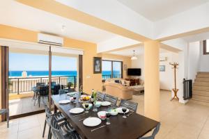 a dining table in a living room with a view of the ocean at Villa Serena in Pomos