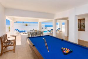 a pool table in a living room with the ocean at Villa Serena in Pomos