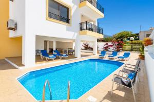 a villa with a swimming pool and chairs at Villa Serena in Pomos