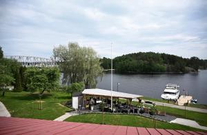 a boat dock with a pavilion next to a river at Boutique hotel SAVOIR in Savonlinna