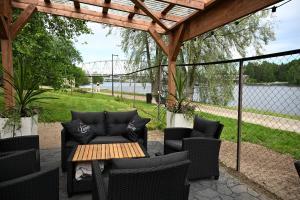 a patio with a table and chairs under a pergola at Boutique hotel SAVOIR in Savonlinna